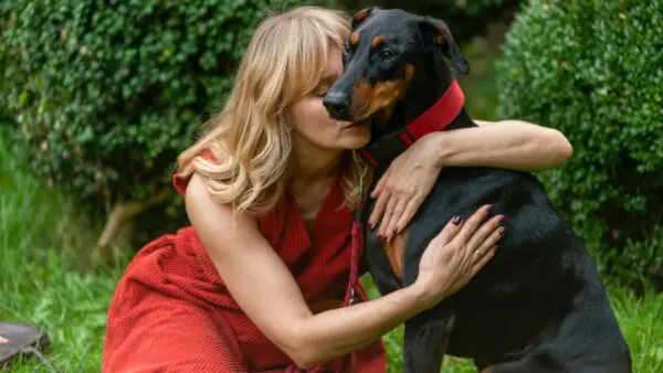 γυναίκα αγκαλιά με σκύλο σε πάρκο