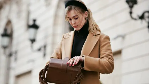 Γυναίκα ανοίγει την τσάντα της στο street style