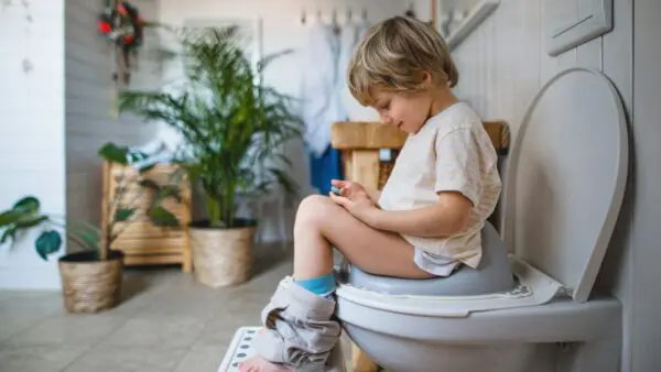 Ένα παιδάκι κάθεται στην λεκάνη του μπάνιου του