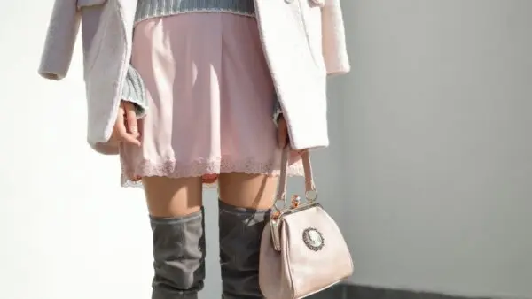 Μια κοπέλα με ροζ φούστα και γκρι μπότες