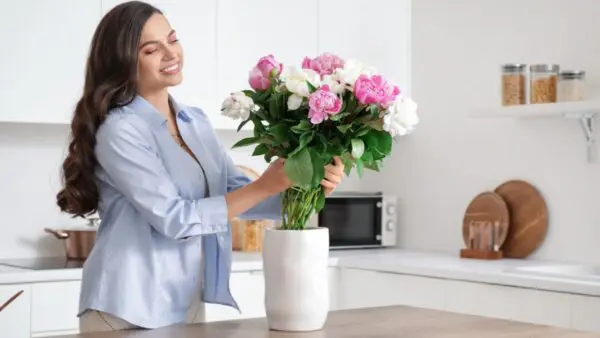 Τα φρέσκα λουλούδια τοποθετεί σε βάζο γυναίκα