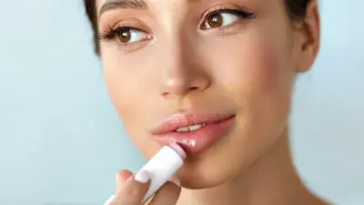 ένα κορίτσι βάζει lip gloss