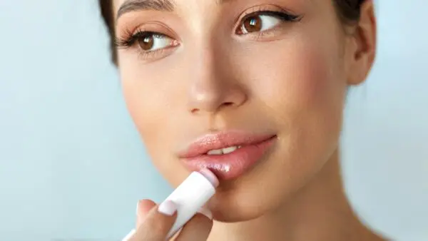 ένα κορίτσι βάζει lip gloss