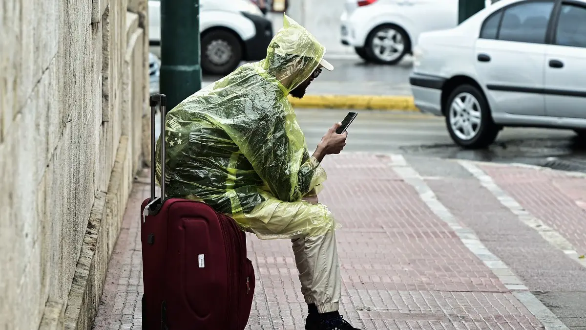 ένας άντρας στο δρόμο με αδιάβροχο