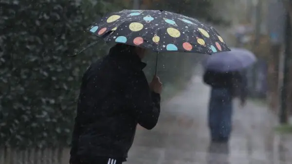 ένας άντρας με ομπρέλα μέσα στη βροχή
