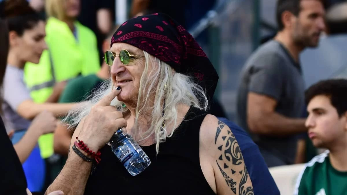 Όλα τα βλέμματα έπεσαν πάνω του: Με αμάνικο, μπαντάνα και μαύρο νύχι στο γήπεδο ο Καρβέλας μαζί με την σύντροφό του