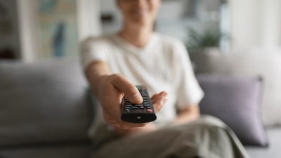 Μια κοπέλα αλλάζει κανάλια στην τηλεόραση