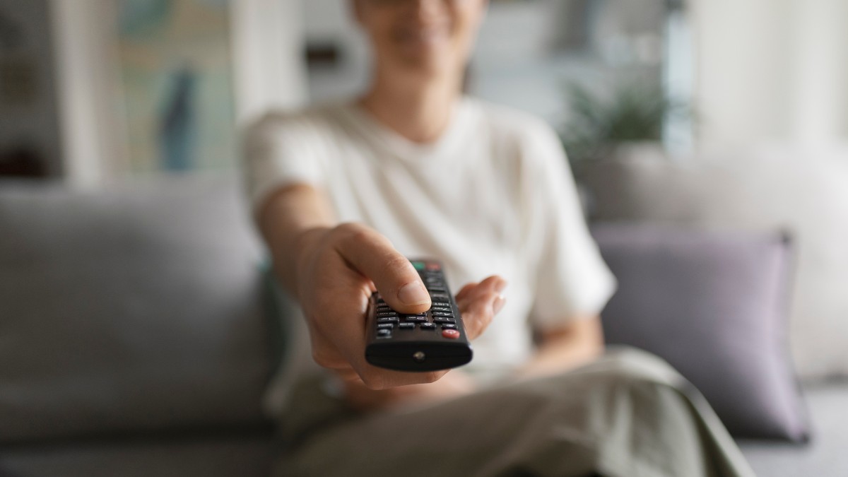 Μια κοπέλα αλλάζει κανάλια στην τηλεόραση