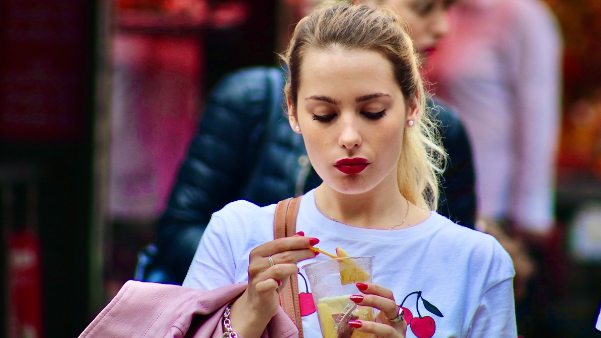 γυναίκα τρώει τυρί στον δρόμο