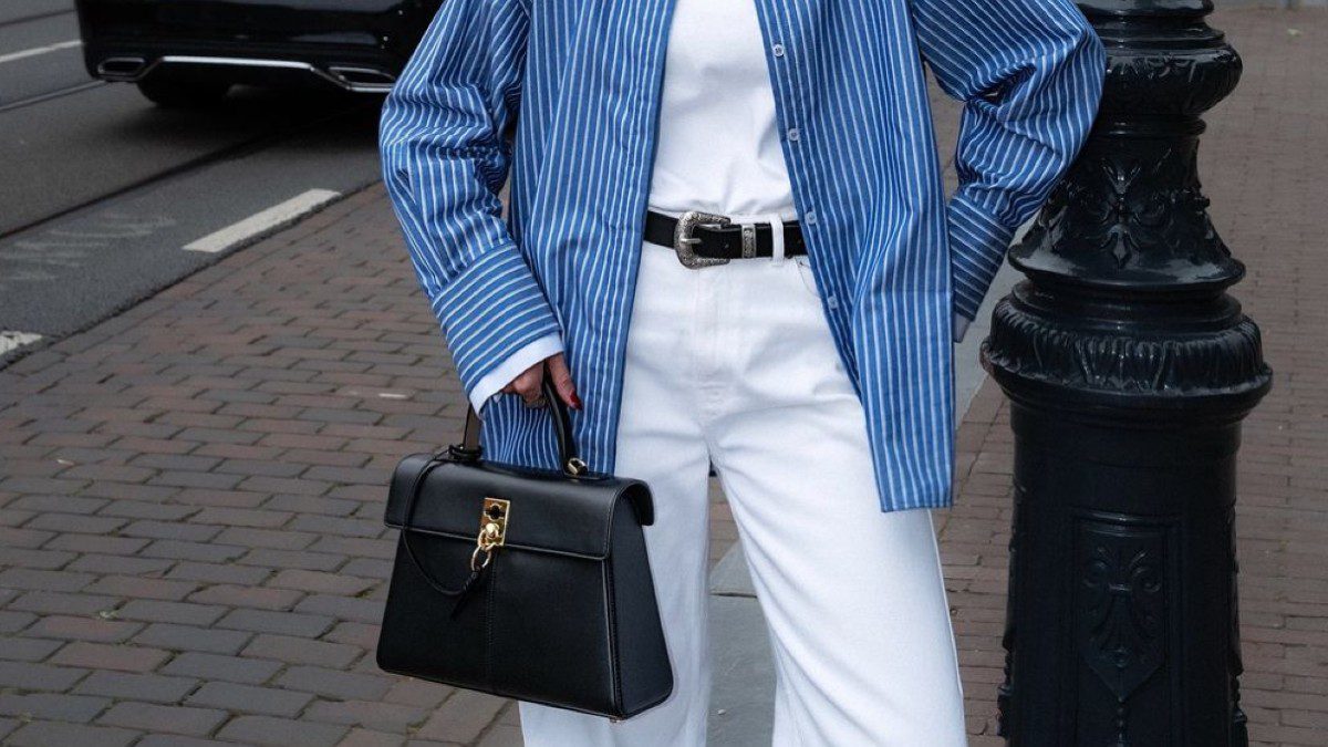 Λευκό τζιν με ριγέ γαλάζιο πουκάμισο και μαύρη τσάντα στο street style