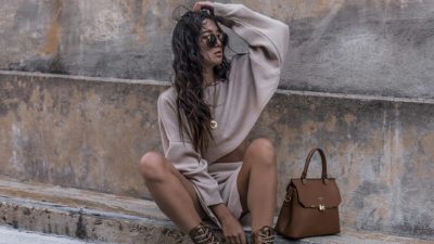 Κοπέλα φοράει μπεζ χρώμα ρούχα και κάθεται σε σκαλάκι