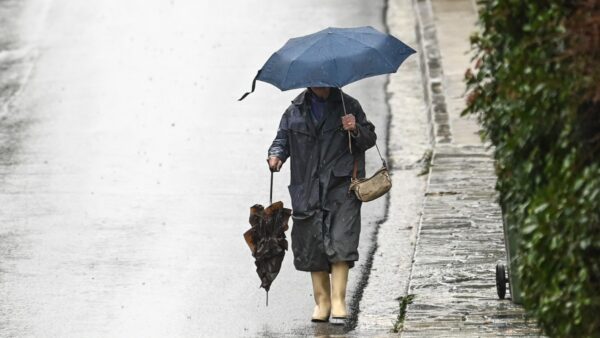 Γυναίκα περπατάει μέσα στην βροχή