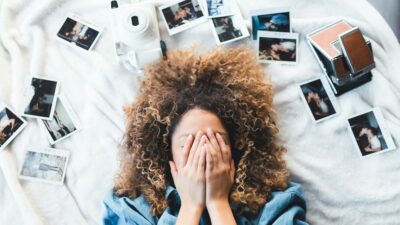 Ένα κορίτσι στο κρεβάτι με φωτογραφίες τριγύρω του