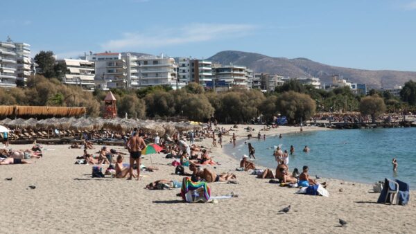 παραλία γεμάτη κόσμο που κάνει μπάνιο