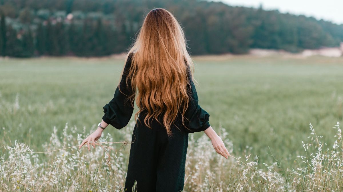Μια κοπέλα με μακριά μαλλιά σε χωράφι