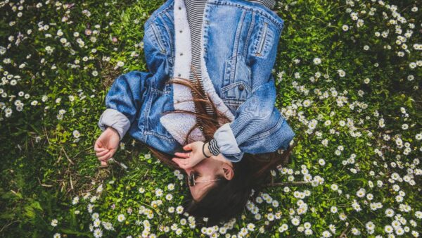 ένα κορίτσι ξαπλωμένο σε ένα λιβάδι