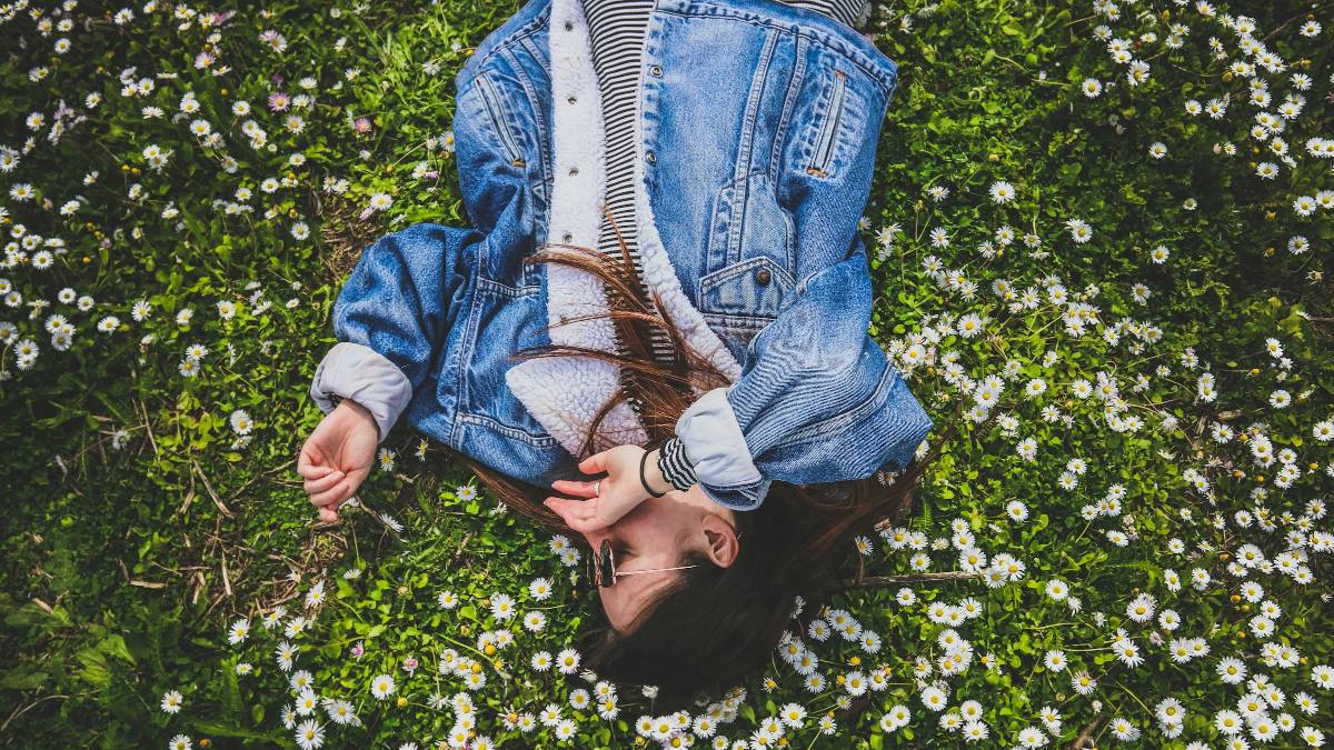 ένα κορίτσι ξαπλωμένο σε ένα λιβάδι