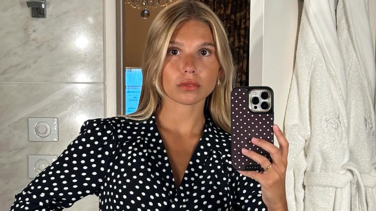 Office looks φοράει κοπέλα μπροστά σε καθρέφτη