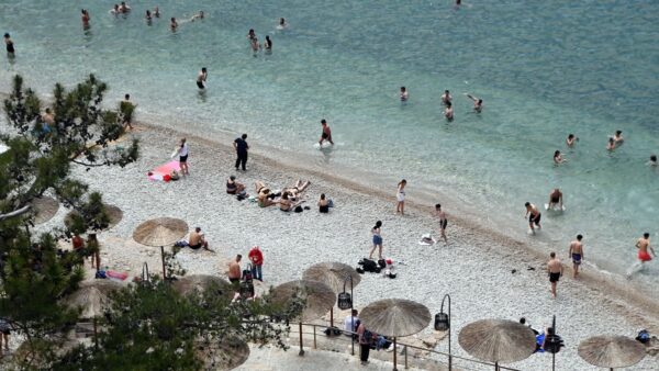 Κόσμος κάνει μπάνιο στην παραλία