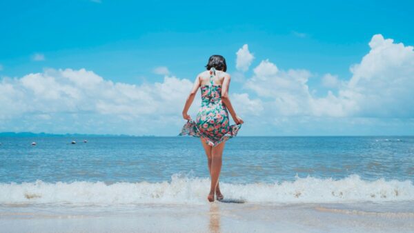 Μια κοπέλα με γαλάζιο φόρεμα στην παραλία