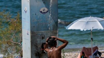 ένα παιδάκι κάνει ντουζ σε παραλία της Αττικής