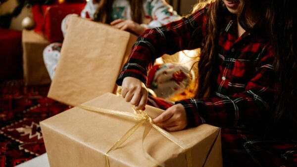 ένα κορίτσι ανοίγει το χριστουγεννιάτικο του δώρο
