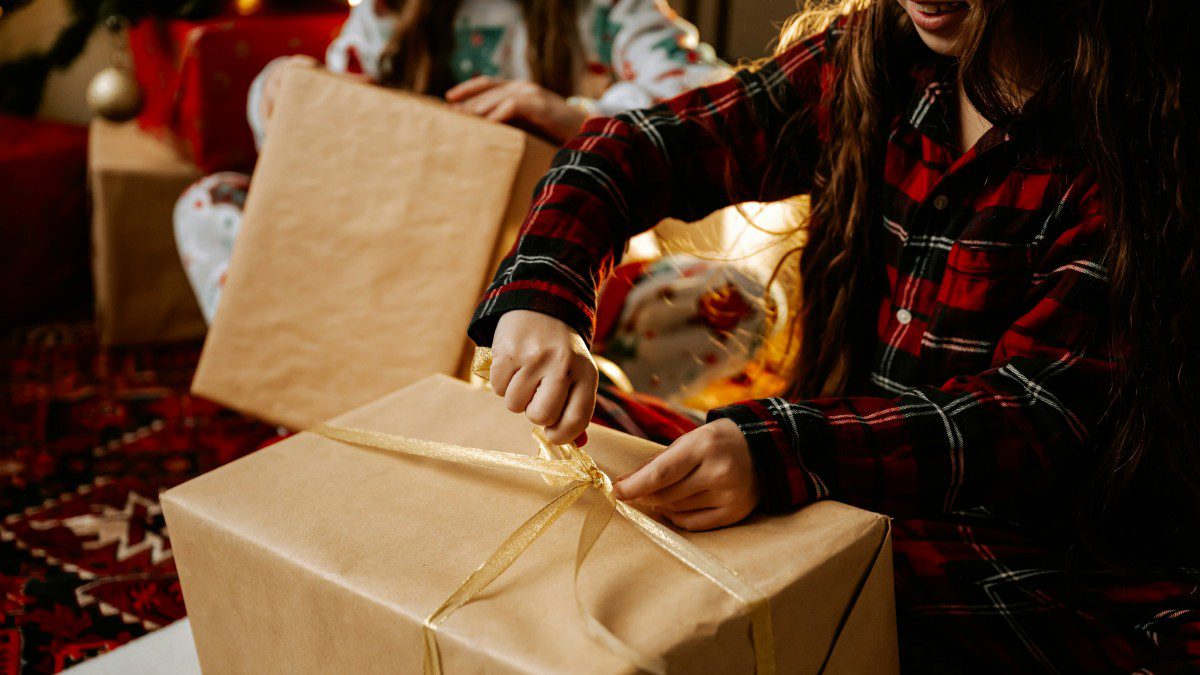 ένα κορίτσι ανοίγει το χριστουγεννιάτικο του δώρο