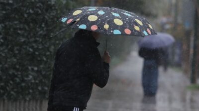 ένας άντρας με ομπρέλα μέσα στη βροχή