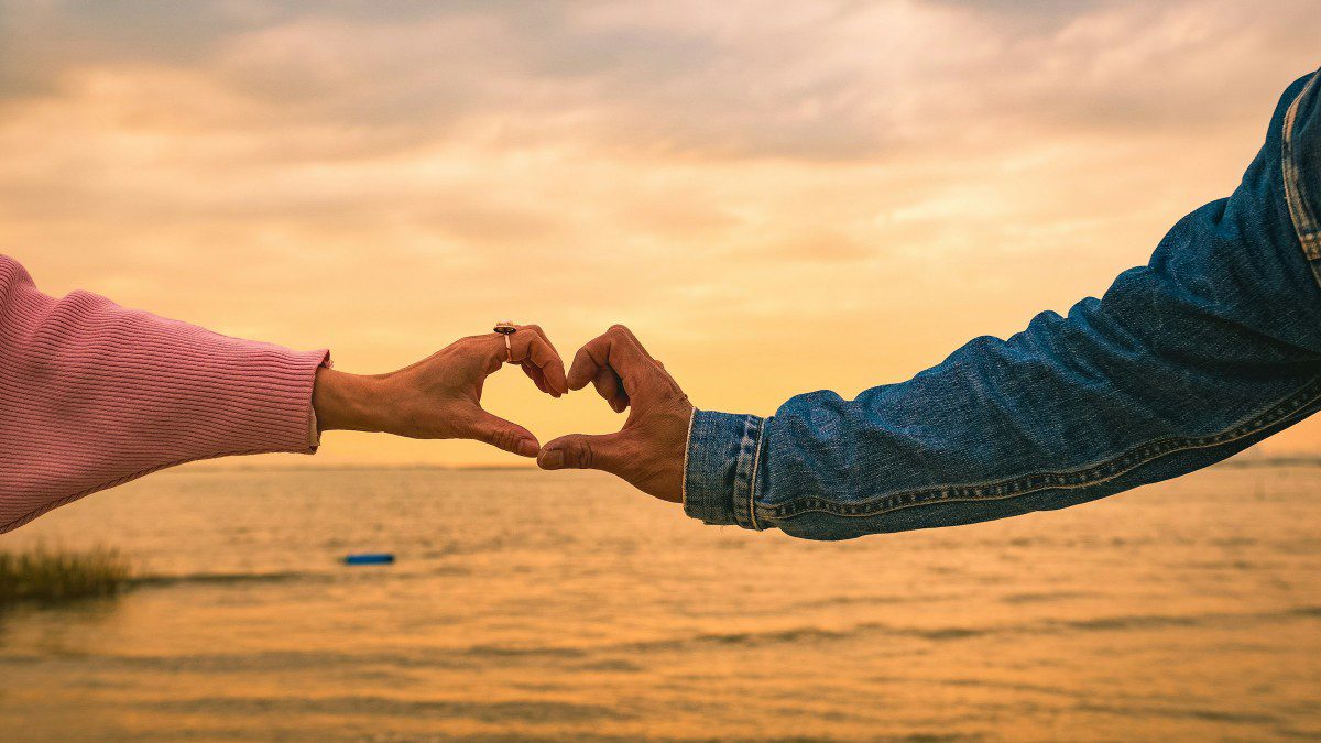 ένα ανδρόγυνο σχηματίζει καρδούλα με το χέρι του