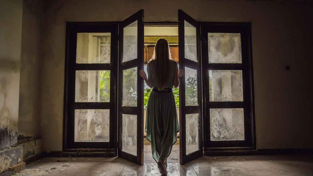 μια κοπέλα ανοίγει μια παλιά πόρτα